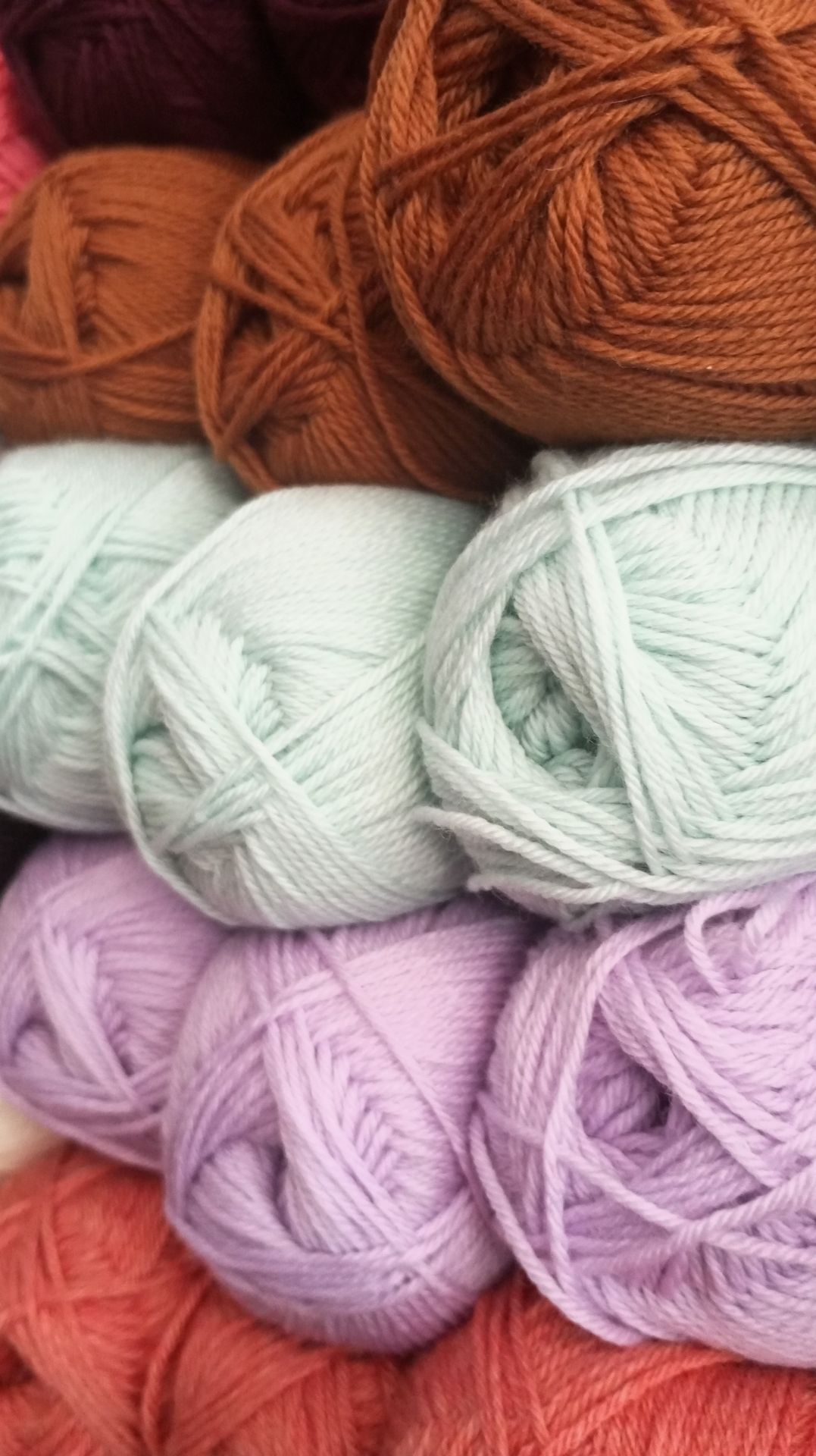 Pile de pelottes de couleur maron, blanc et rose